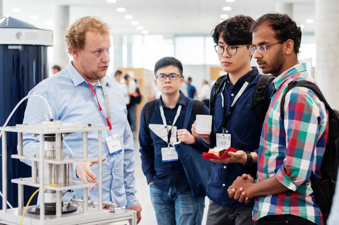 People discussing about a magnetocaloric cooling device on an exhibition