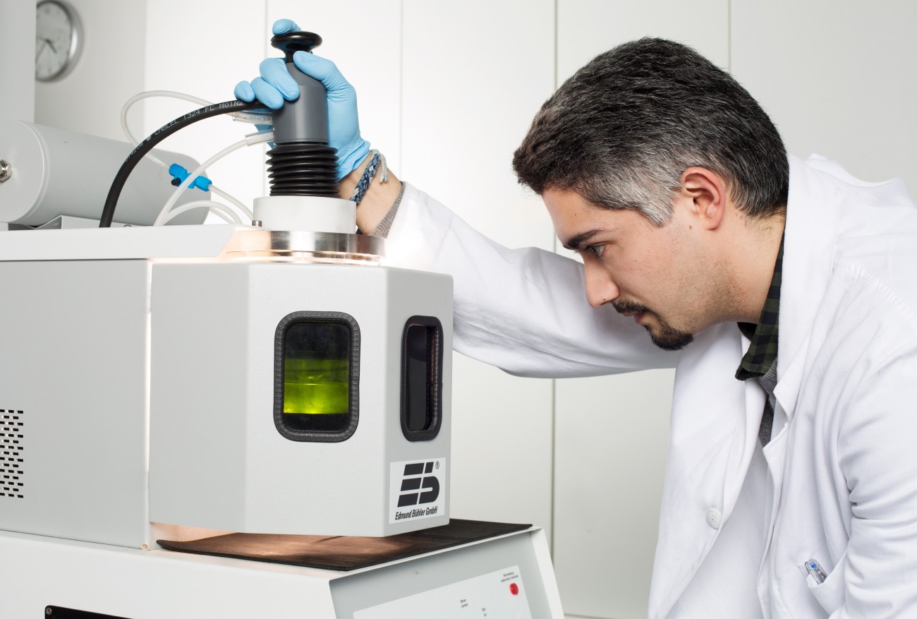 A researcher working on an arc melter